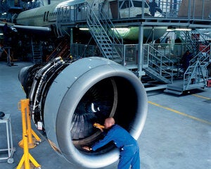 mechanic looking into an aircraft engine