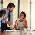 Two men and a woman at a table having a business meeting
