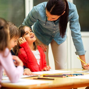 teacher speaking to a table of young learners