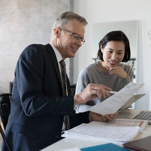 Financial advisor and woman with laptop meeting in dining room