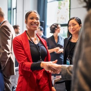 woman in red jacket shaking hands