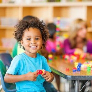 young child playing with legos