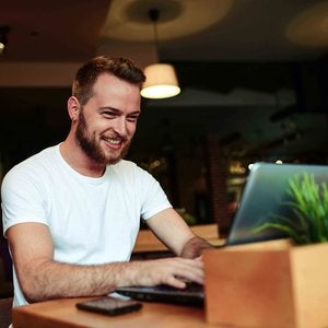 man in white shirt on laptop