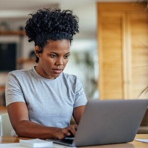 Concentrating adult woman working on laptop