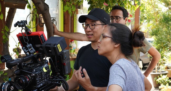 Man and woman looking at a film camera