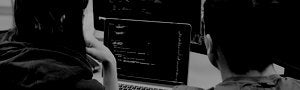 two programmers looking at a laptop together