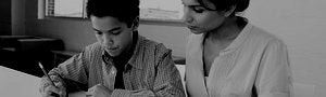 Teacher sitting with young student