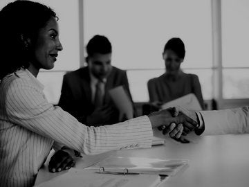 Woman shaking man's hand in meeting.