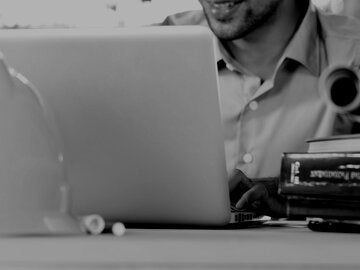 Construction manager in office typing on laptop.