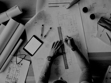 Overhead view architect drafting blueprints at table