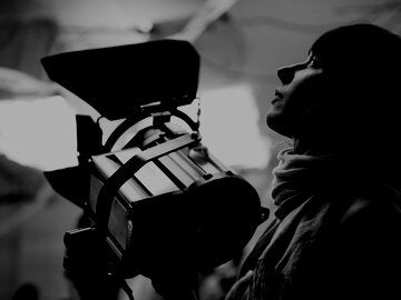 Filmmaker Adjusting Light
