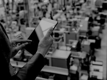 man with tablet overseeing factory