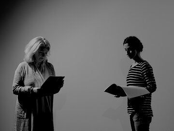 two women reading scripts