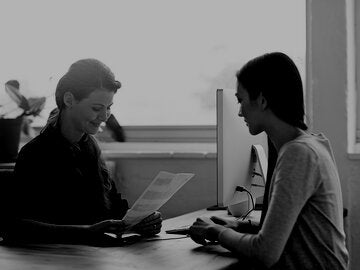 two women sitting at desk interview situation
