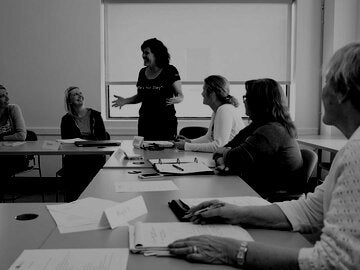 Writers discussing story around a table in a writers room.