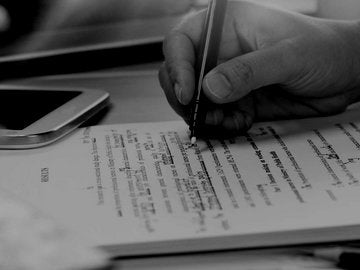 Copywriter making proofreading notes on a print out.