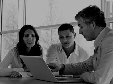 male and female couple with male advisor looking at computer