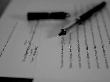 Red pen editing a manuscript