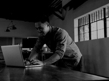 Mixed race businessman working on laptop in office