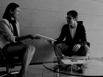 Businesswoman handing documents to client