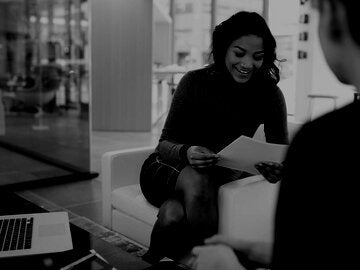 Businesswomen reviewing paperwork in office lobby