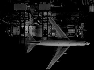 airplane flying over a stocked tanker ship