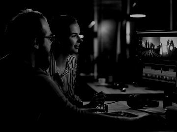 Man and woman editing video together