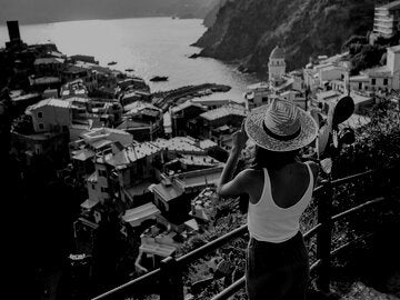 Woman taking a photo of a exotic village by the water