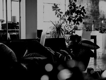 woman writing and relaxing on her sofa