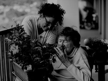 older person smelling flowers
