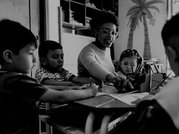 Teacher demonstrating art to children
