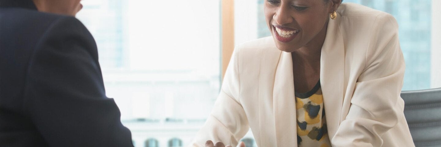 professional showing another individual something on a tablet