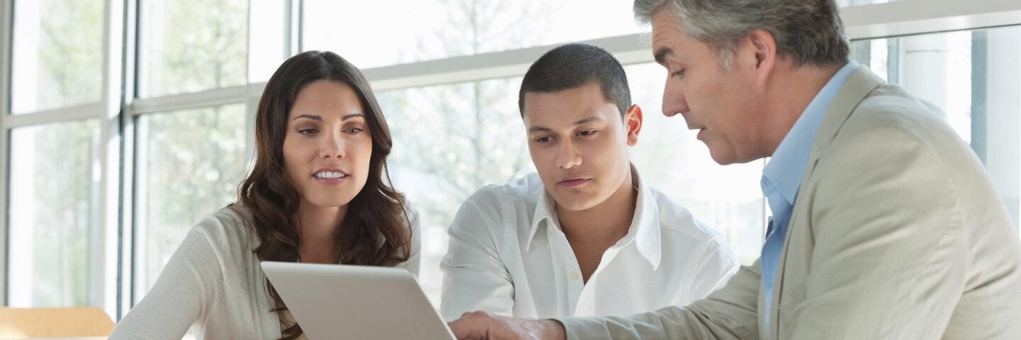 professional sitting with a couple looking at a laptop