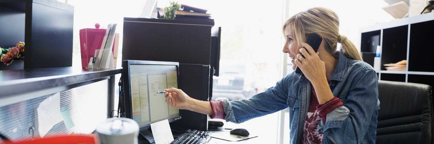 Accounting reviewing digital invoice while on phone