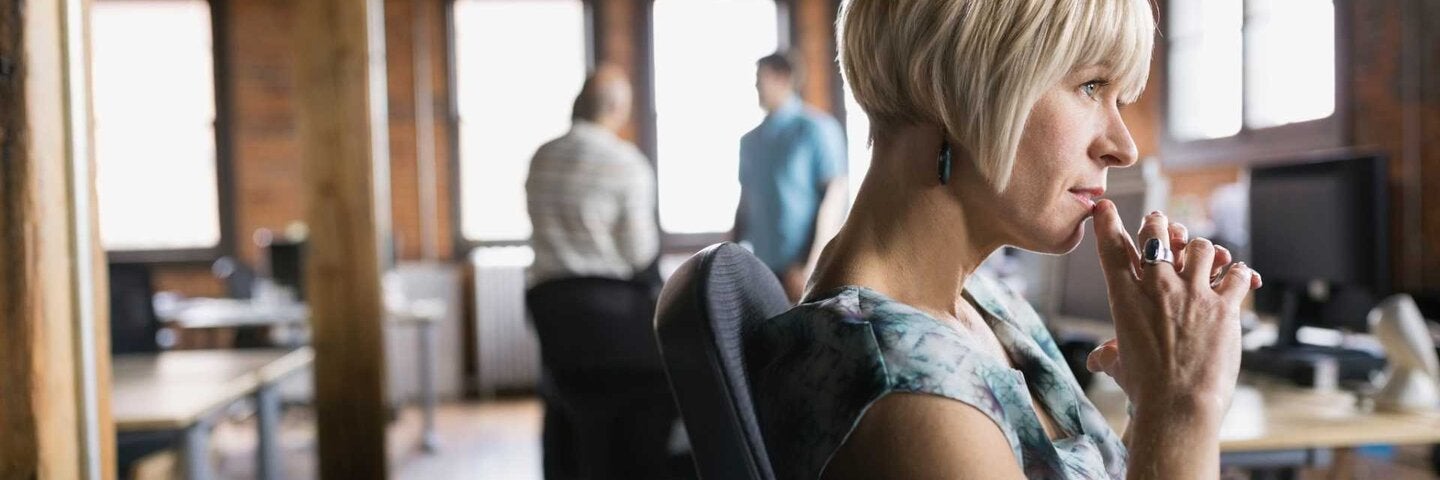 Woman contemplating in office.