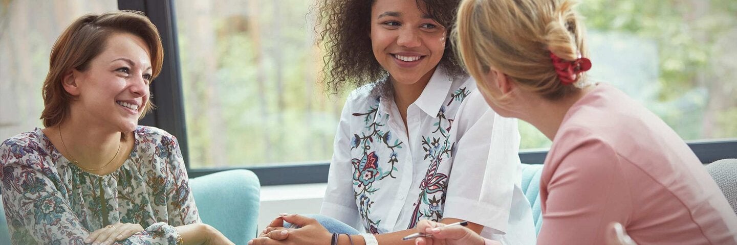 Smiling women talking in group therapy session