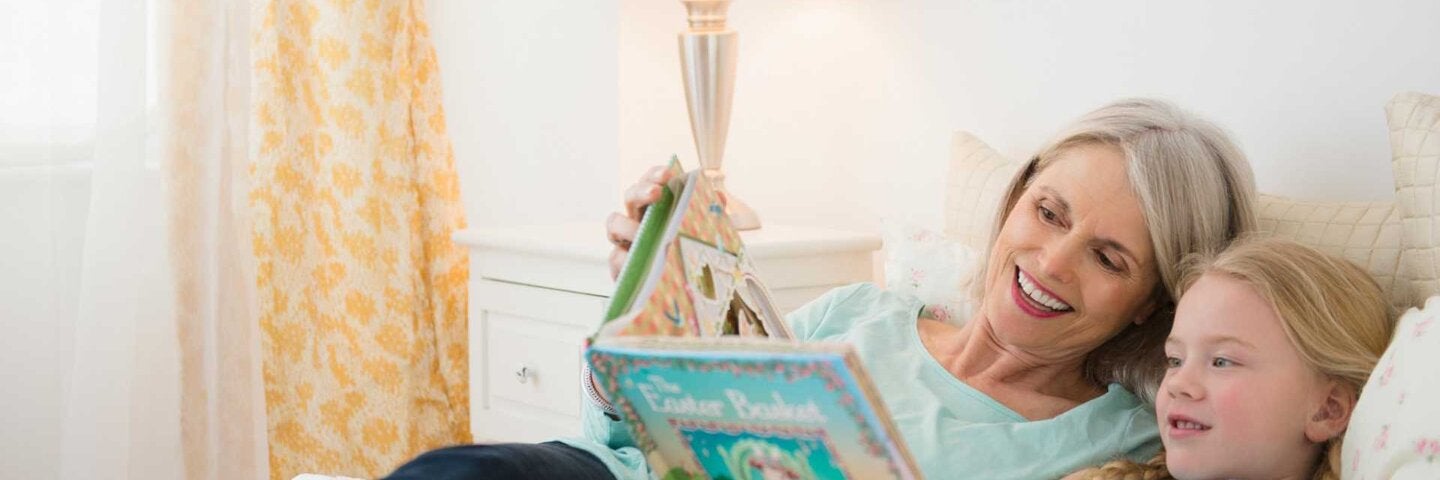 Senior woman and granddaughter reading in bed