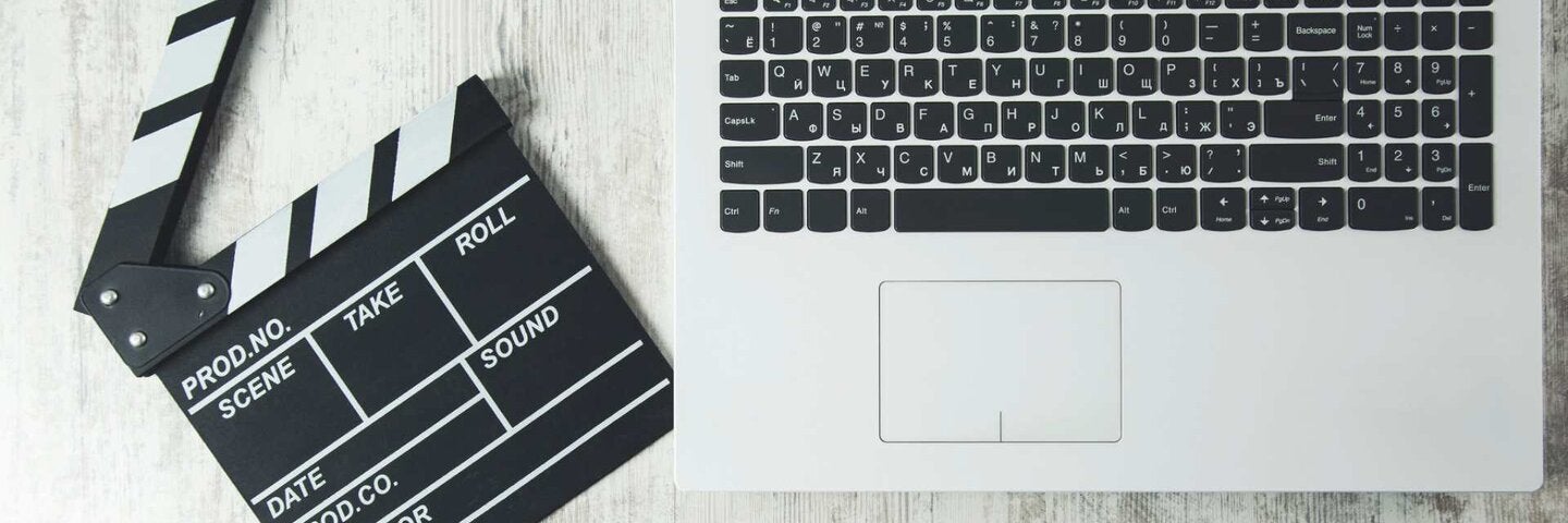 Film clapboard lying next to laptop