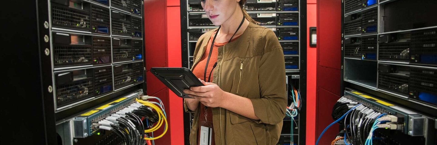Caucasian technician using digital tablet in computer server room