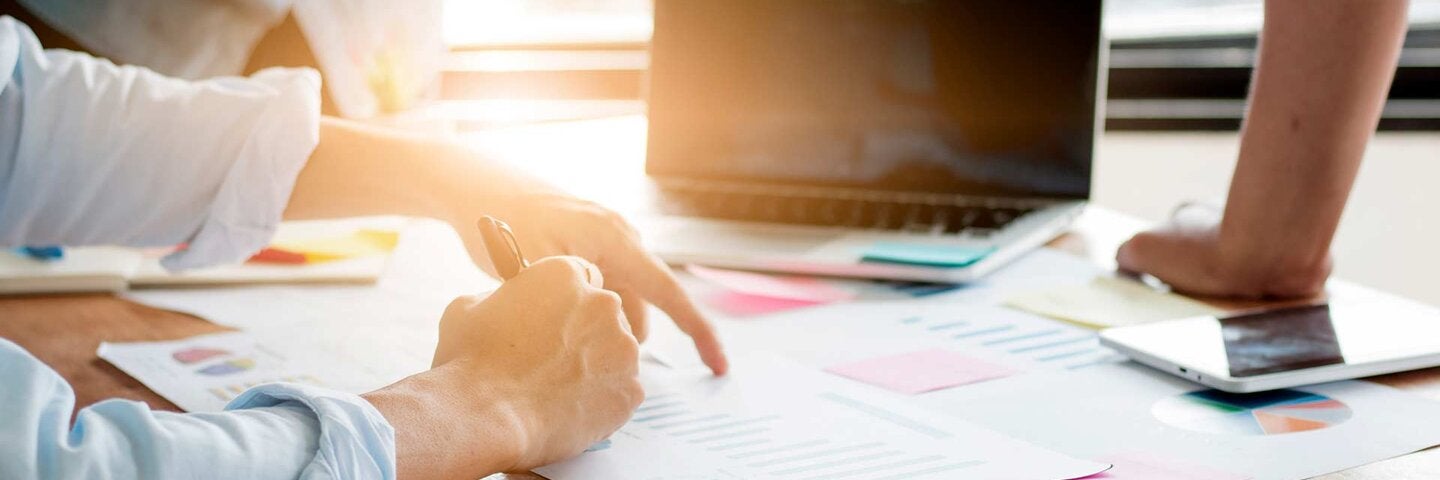 people around computer and financial documents close up