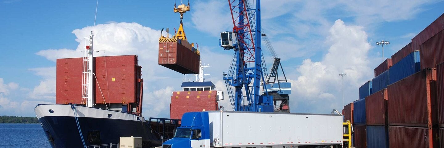 tractor trailer sits in the foreground at a commercial dock