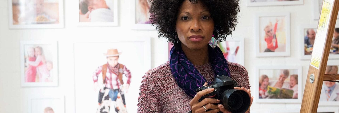 female photographer holding camera in studio