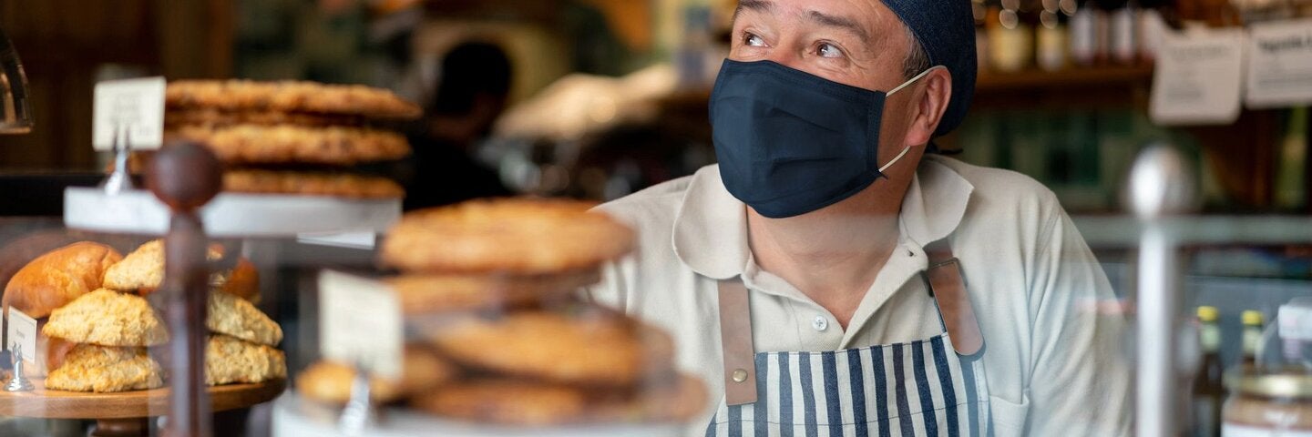 Man working at a coffee shop wearing a facemask