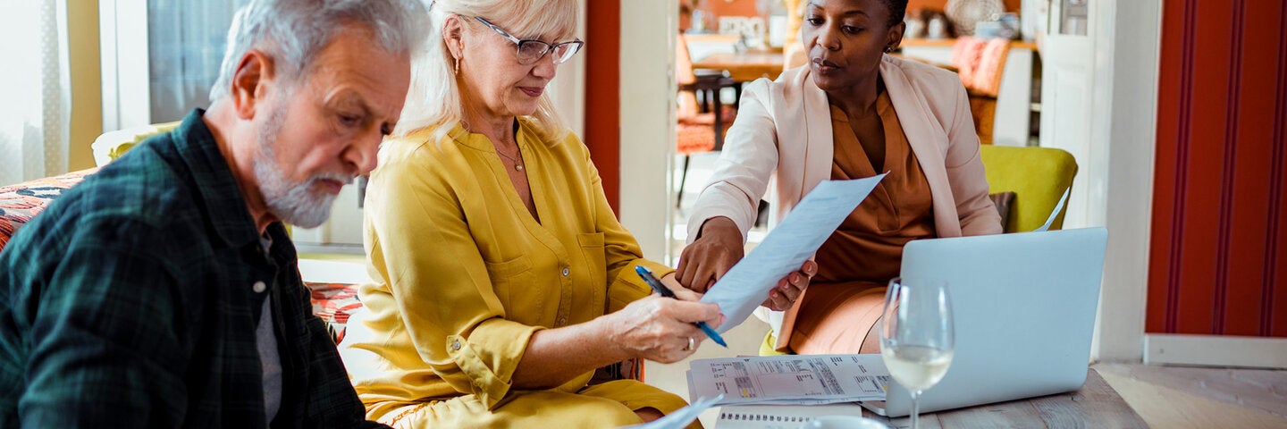 Woman helping couple with financial planning in their home