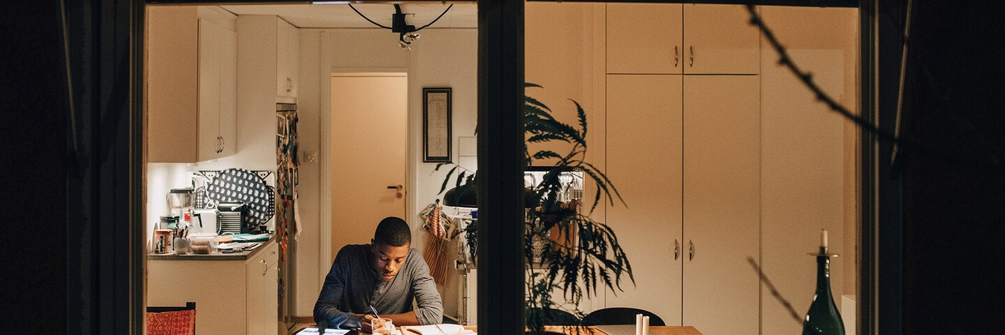 african-american man writing at his dining room table