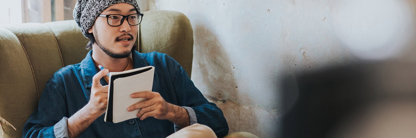 man discussing and taking notes