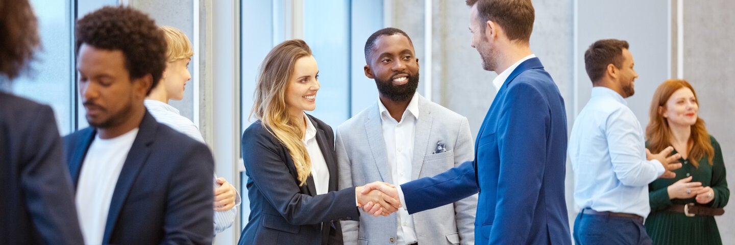 People connecting out in the lobby and shaking hands