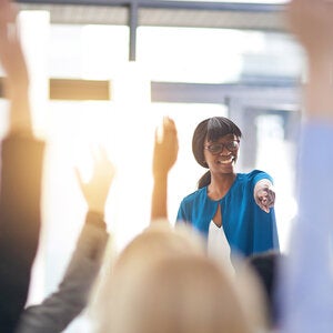 students raise their hands in the classroom