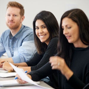 three students in a writers' program class