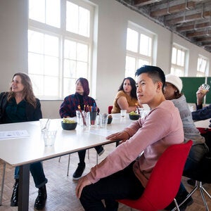 writing students sitting at a long table